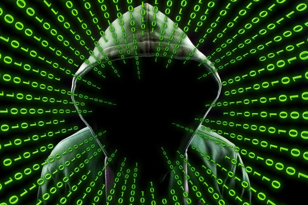 Hacker in hoodie with green computer code around his head